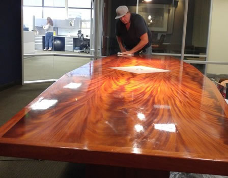 Close-up of a pro repairing a wood table scratch in a Long Beach, CA home
